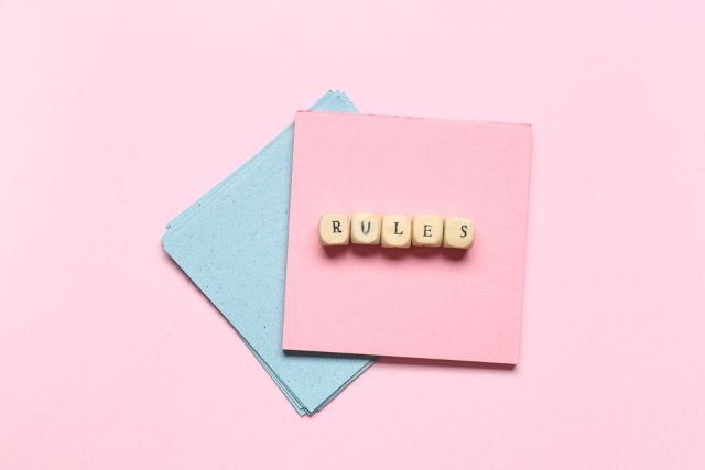 水色とピンクの紙の上に置かれたPenaltyと言う文字の書いたブロック